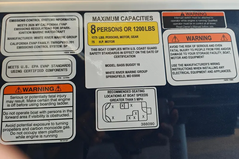 Slide: The Image of Sun Tracker Bass Buggy 18 DLX 2026 safety and capacity labels, including warnings and emissions information. - 18