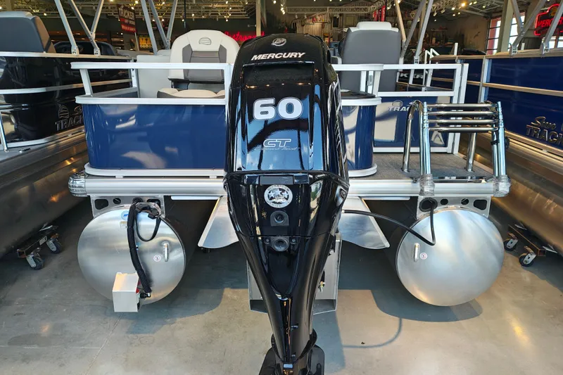 Slide: The Image of 2026 Sun Tracker Bass Buggy 18 DLX pontoon boat with Mercury 60 HP engine displayed indoors. - 3
