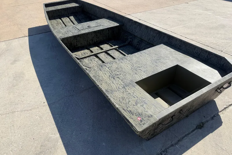 Slide: The Image of 2026 Tracker Grizzly 15 Jon boat on concrete surface, showcasing its rugged design. - 2