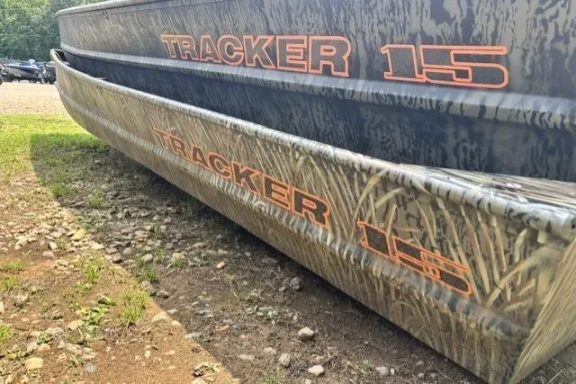 The Image of 2026 Tracker Grizzly 15 Jon boat with camouflage design on rocky terrain. - 0