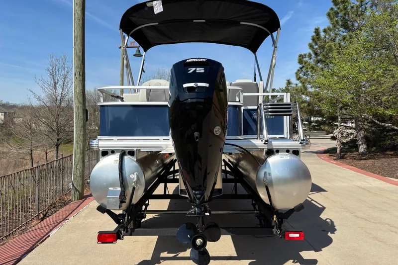 Slide: The Image of 2026 Sun Tracker Bass Buggy 18 DLX pontoon boat with Mercury 75 engine, parked outdoors. - 1
