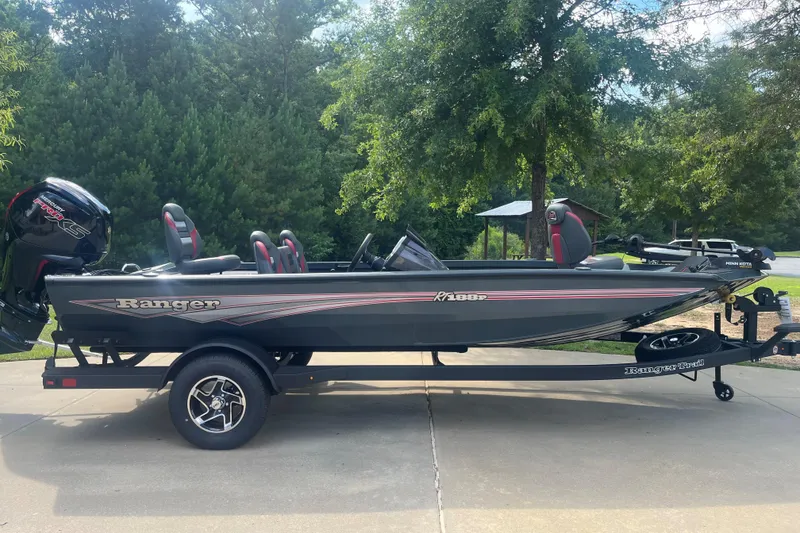 The Image of 2026 Ranger RT188P fishing boat on trailer, parked outdoors with trees in background. - 0