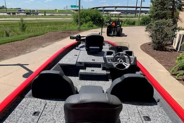 Slide: The Image of 2026 Tracker Pro Team 175 boat with red trim, parked on a sunny day. - 13