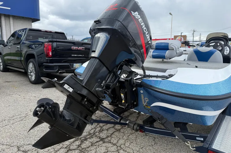 Slide: The Image of 2005 Nitro 700 LX SC boat with Mercury outboard motor, parked near a GMC Denali truck. - 5