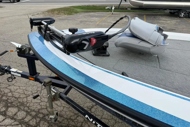 Slide: The Image of 2005 Nitro 700 LX SC boat with trolling motor on trailer, parked on pavement. - 7
