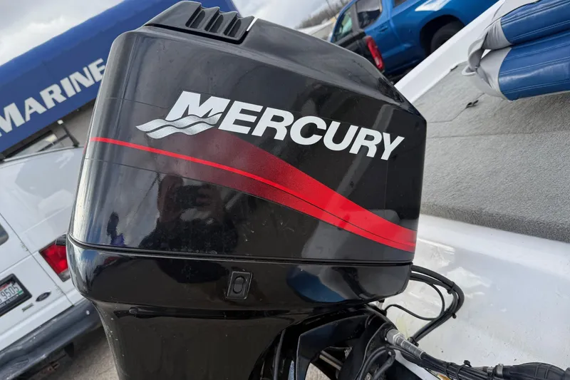 Slide: The Image of Mercury outboard motor on a 2005 Nitro 700 LX SC boat, parked near marine dealership. - 8