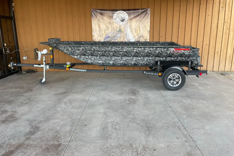 The Image of 2026 Reaper Boats 653 Timber Reaper on trailer, camouflage design, parked outside wooden building. - 0