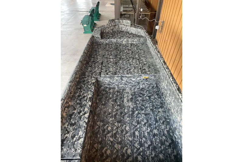 Slide: The Image of 2026 Reaper Boats 653 Timber Reaper with camouflage interior, docked indoors. - 11