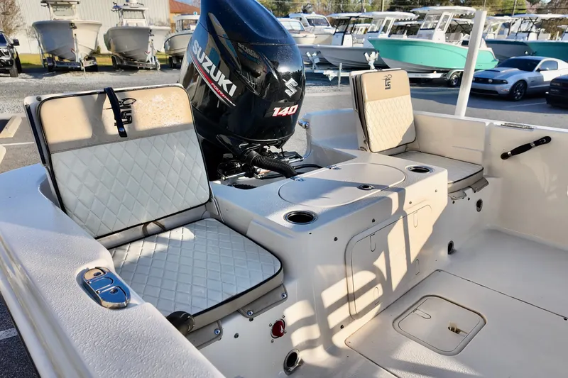 Slide: The Image of 2020 Carolina Skiff 21 LS boat interior with Suzuki 140 engine, featuring cushioned seating. - 10