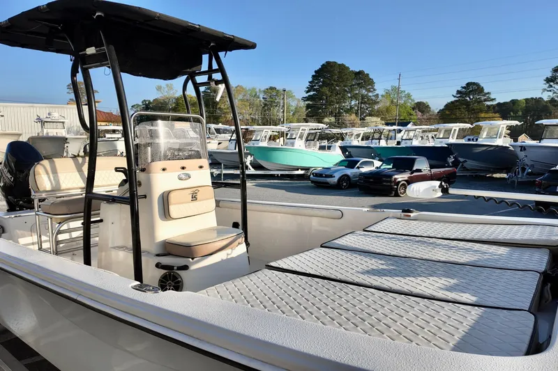 Slide: The Image of 2020 Carolina Skiff 21 LS boat in a marina with other boats and cars. - 12