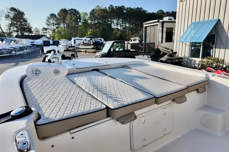 Slide: The Image of 2020 Carolina Skiff 21 LS boat with cushioned seating, parked outdoors at a dealership. - 6