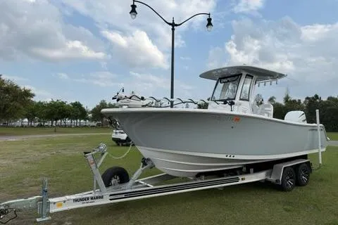 The Image of 2024 Sportsman Heritage 231 Center Console boat on trailer, parked on grass. - 0