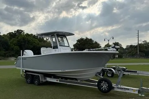 Slide: The Image of 2024 Sportsman Heritage 231 Center Console boat on trailer, parked on grass under cloudy sky. - 5