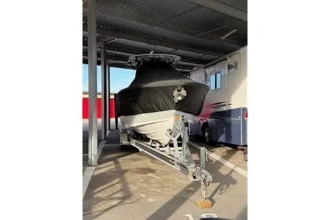 Slide: The Image of 2024 Sportsman Heritage 231 Center Console boat on trailer under shelter. - 6