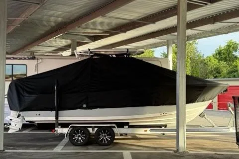 Slide: The Image of 2024 Sportsman Heritage 231 Center Console boat covered, parked under a shelter. - 7
