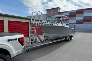 Slide: The Image of 2024 Sportsman Heritage 231 Center Console boat on trailer, parked near storage units. - 8