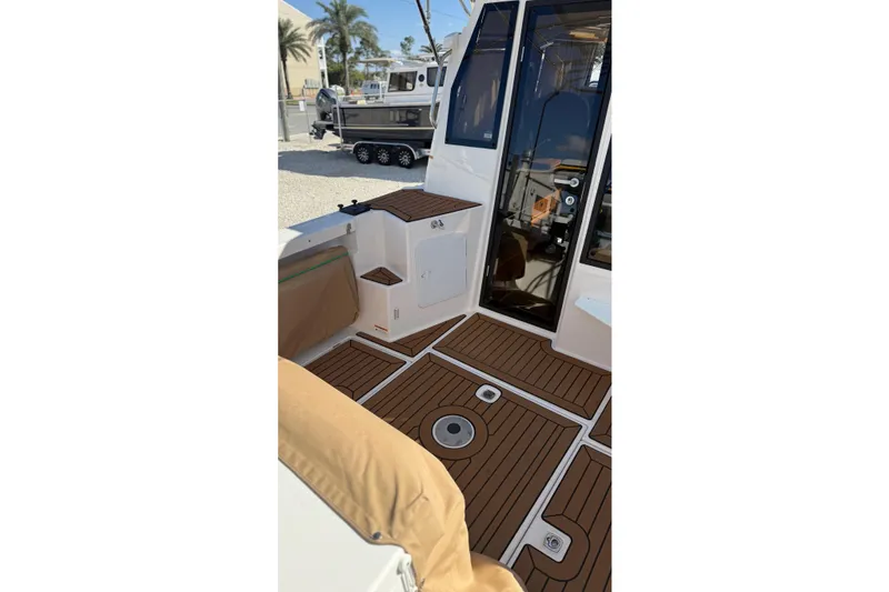 Slide: The Image of 2024 Ranger Tugs R-27 boat interior with teak flooring and seating area. - 10
