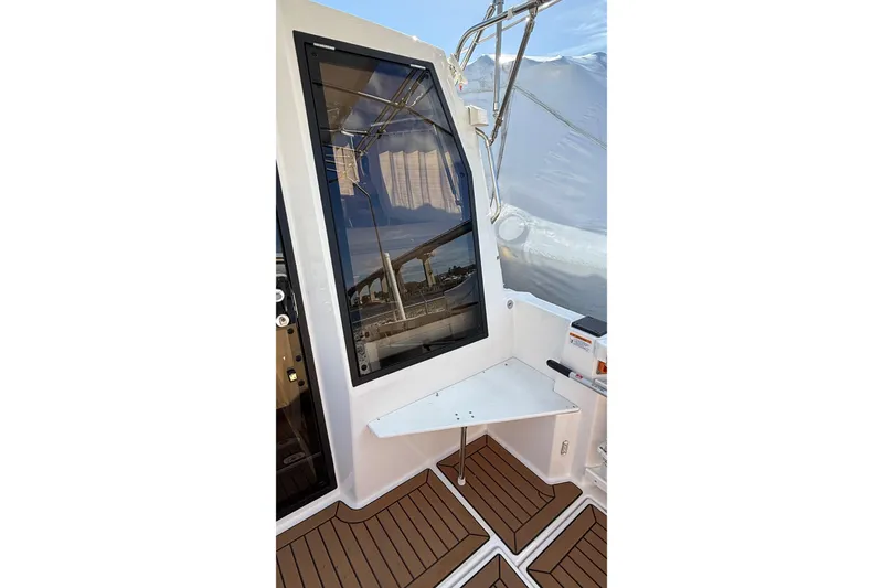 Slide: The Image of 2024 Ranger Tugs R-27 boat interior with sleek window and wooden flooring. - 14