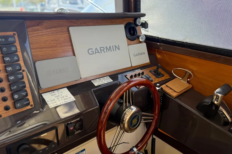 Slide: The Image of 2024 Ranger Tugs R-27 helm with Garmin navigation and Yamaha controls. - 16