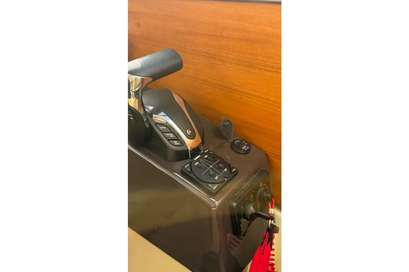 Slide: The Image of 2024 Ranger Tugs R-27 control panel with throttle and joystick. - 19