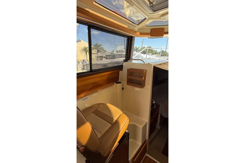 Slide: The Image of 2024 Ranger Tugs R-27 interior with leather seating and wood accents, showcasing luxury design. - 22