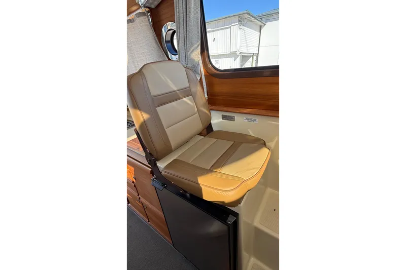 Slide: The Image of 2024 Ranger Tugs R-27 interior with tan leather seat and wooden accents. - 24