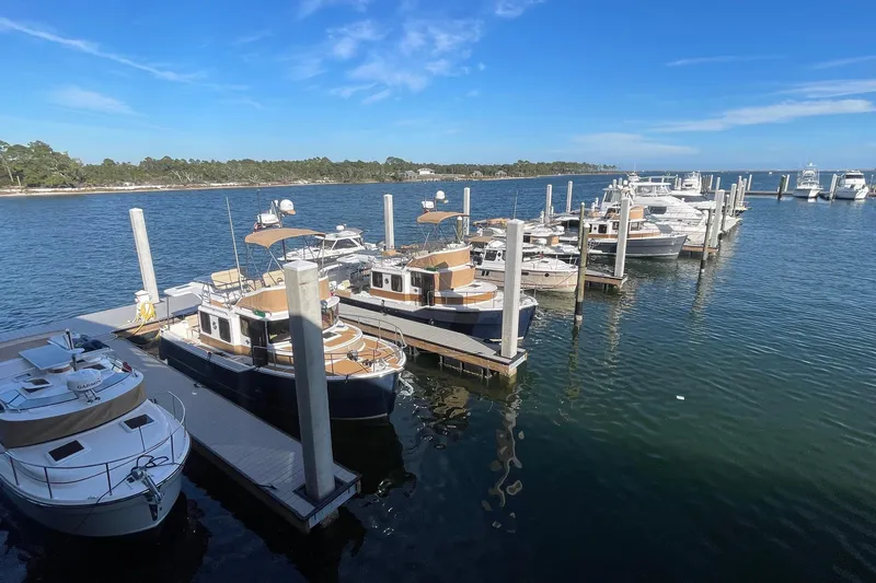 Slide: The Image of Marina with 2024 Ranger Tugs R-27 boats docked under clear blue sky. - 30
