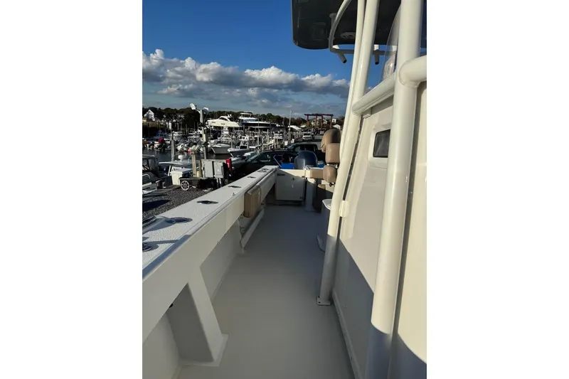 Slide: The Image of 2019 Parker 2501 Center Console boat docked at marina under blue sky. - 10