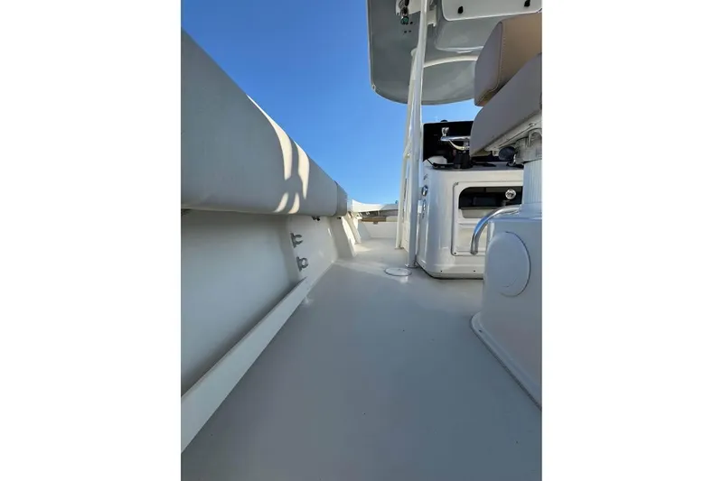 Slide: The Image of 2019 Parker 2501 Center Console boat interior with seating and console, under clear blue sky. - 9