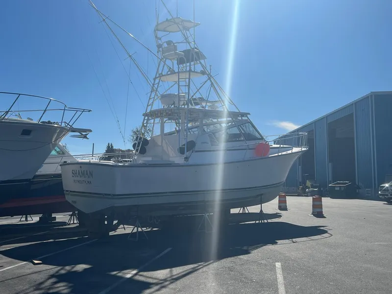 Slide: The Image of Henriques 38 El Bravo 1997 boat in dry dock under sunny sky. - 3