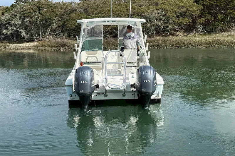 Slide: The Image of 2023 World Cat 230 DC boat with dual engines on calm water. - 10