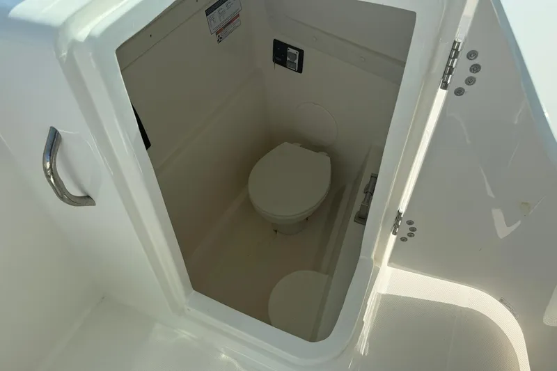 Slide: The Image of 2023 World Cat 230 DC boat interior with compact marine toilet. - 16