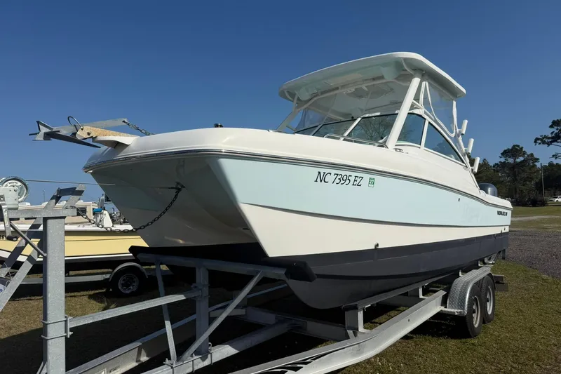 Slide: The Image of 2023 World Cat 230 DC boat on trailer under clear blue sky. - 17