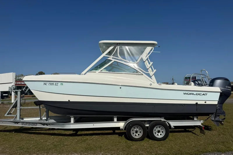 Slide: The Image of 2023 World Cat 230 DC boat on trailer, side view under clear blue sky. - 18