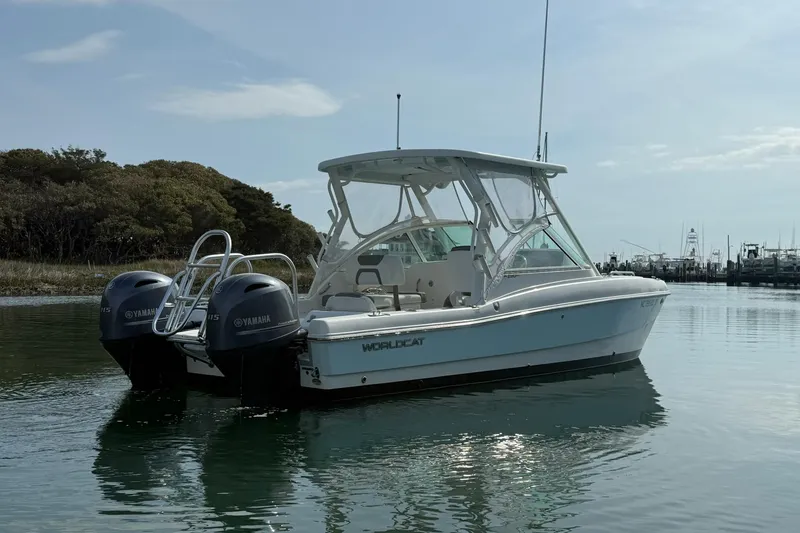 Slide: The Image of 2023 World Cat 230 DC boat with twin Yamaha engines on calm water. - 2