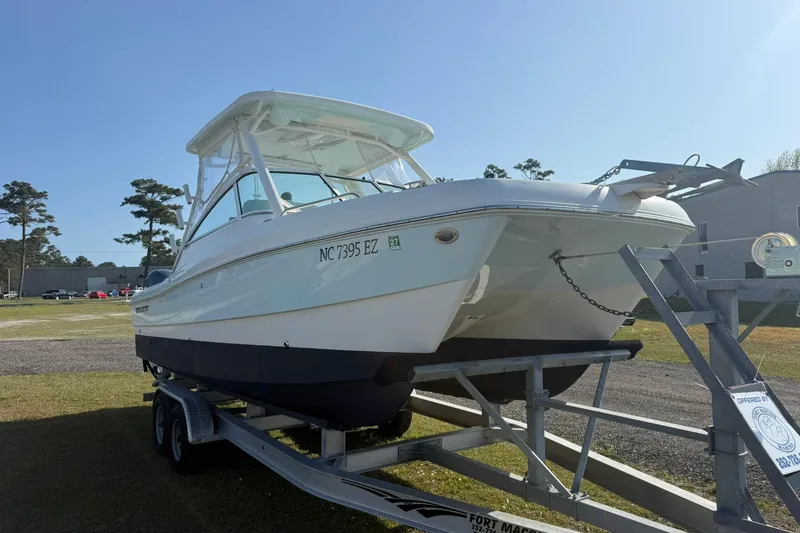 Slide: The Image of 2023 World Cat 230 DC boat on trailer under clear blue sky. - 21