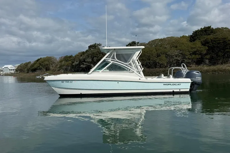 Slide: The Image of 2023 World Cat 230 DC boat on calm water with scenic background. - 7