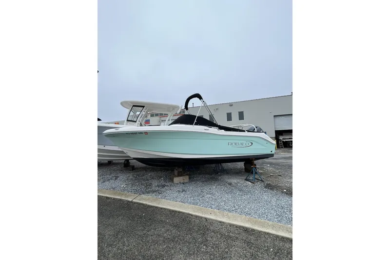 Slide: The Image of 2019 Robalo R207 Dual Console boat on display in a marina setting. - 2