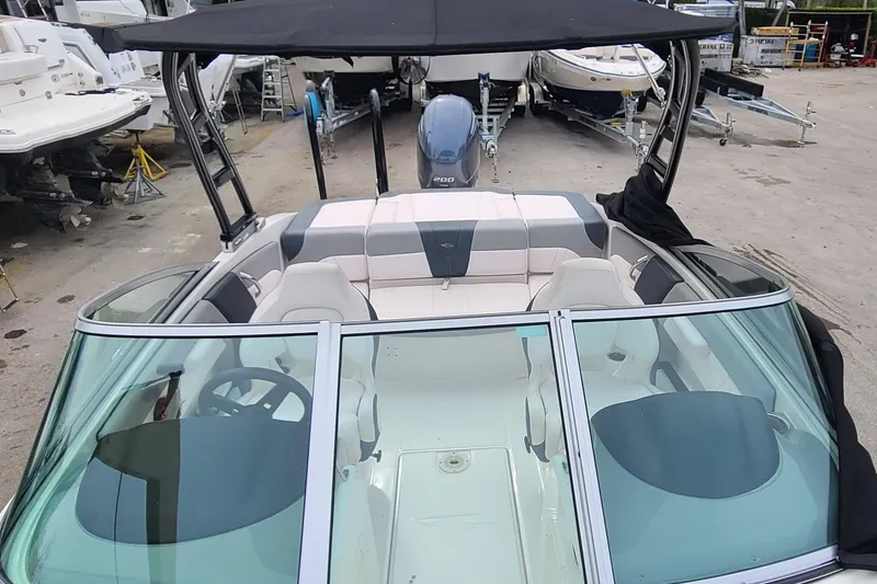 Slide: The Image of 2020 Chaparral 21 SSi OB boat with seating and canopy, parked in a marina. - 18