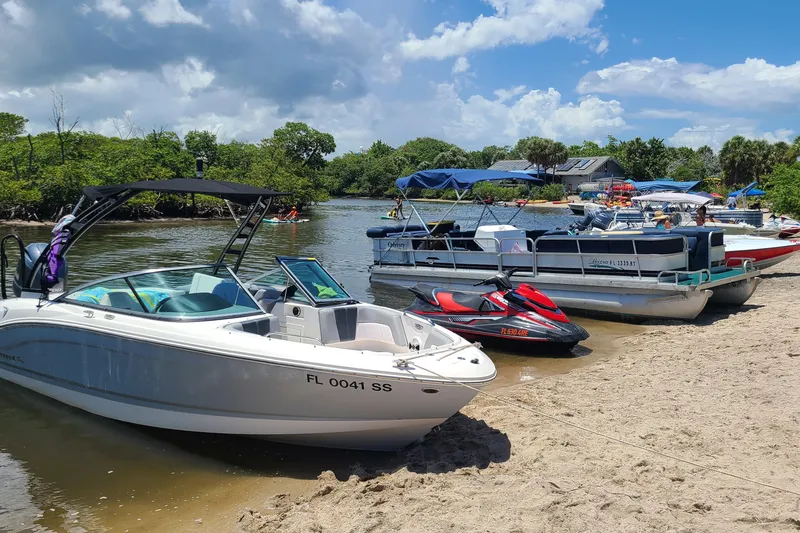 Slide: The Image of Chaparral 21 SSi OB 2020 boat docked on a sunny beach with other watercraft. - 8