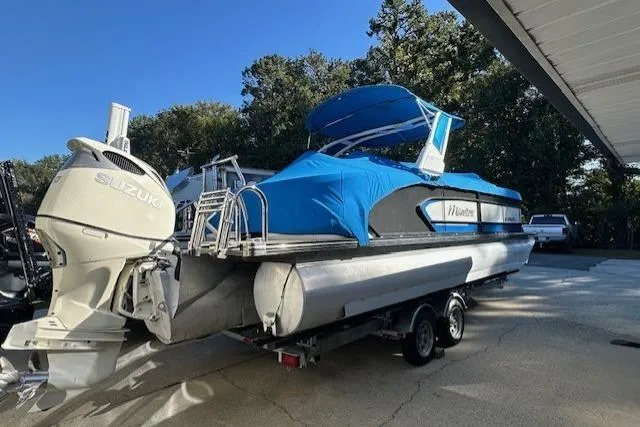 Slide: The Image of 2020 Manitou 25 X-Plode RFW pontoon boat with blue cover and Suzuki outboard motor. - 12