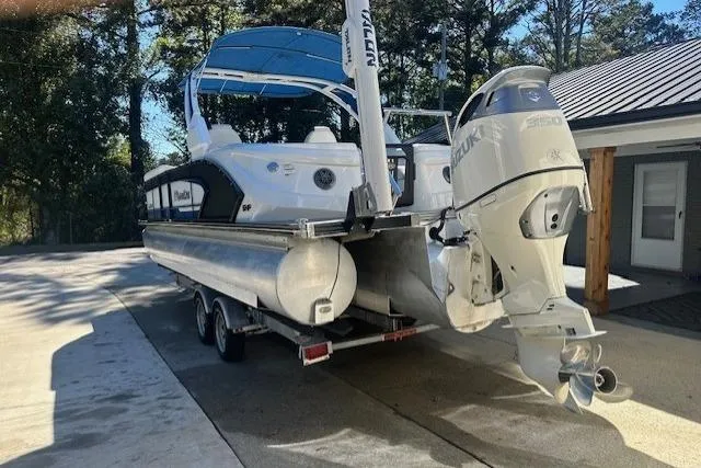 Slide: The Image of 2020 Manitou 25 X-Plode RFW pontoon boat with Suzuki outboard motor on trailer. - 2