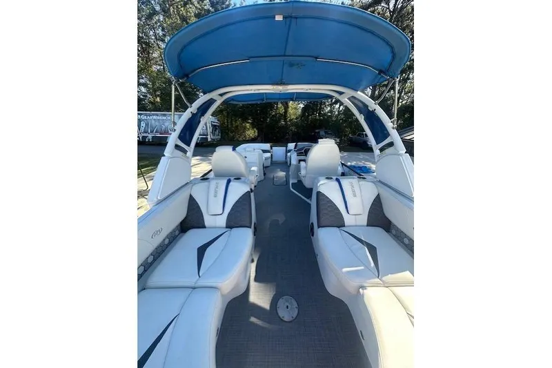 Slide: The Image of 2020 Manitou 25 X-Plode RFW pontoon boat interior with blue canopy and white seating. - 9