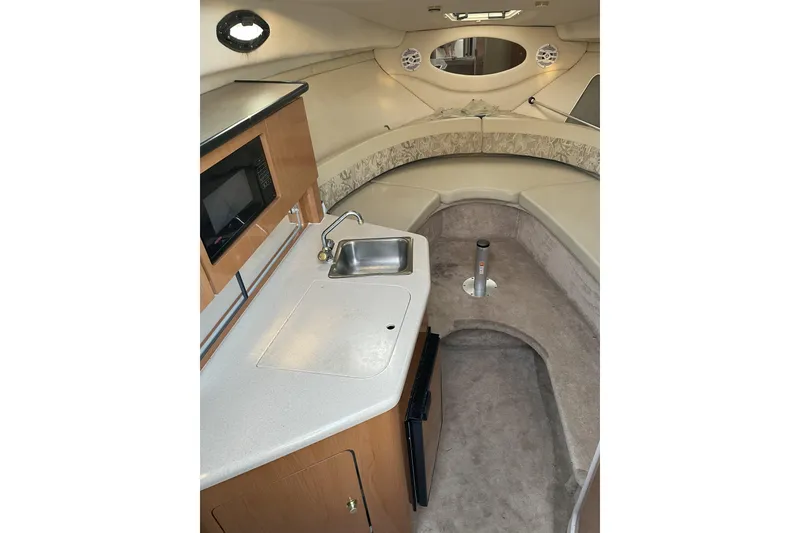 Slide: The Image of 2001 Regal Commodore 2660 boat interior with kitchenette and seating area. - 14