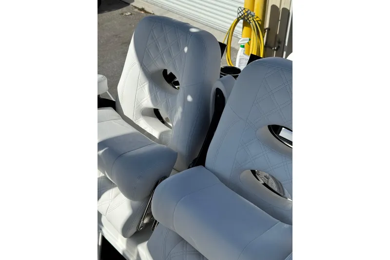 Slide: The Image of White cushioned seating on 2026 BlackJack 256 Coastal boat, featuring diamond stitching. - 15