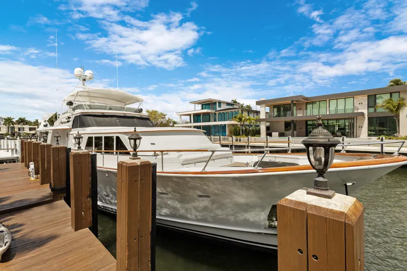 The Image of Luxury yacht docked near modern waterfront homes under a clear blue sky. - 0