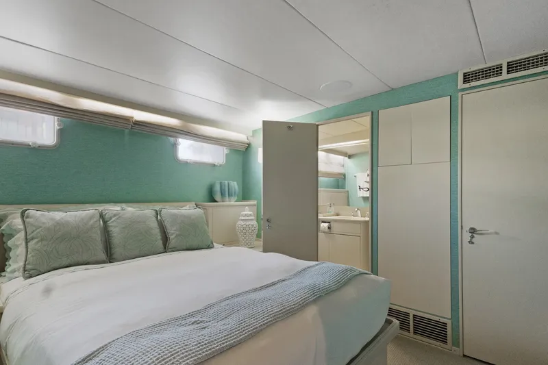 Slide: The Image of Luxurious bedroom interior on a 1985 Burger yacht, featuring elegant decor and ensuite bathroom. - 21