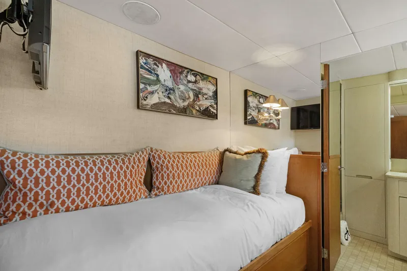 Slide: The Image of Cozy bedroom in a 1985 Burger yacht with abstract art and patterned pillows. - 24