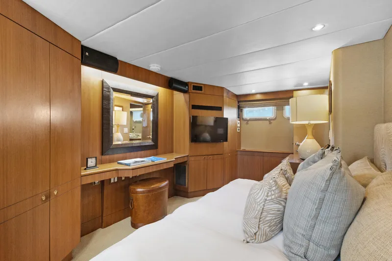 Slide: The Image of Luxurious 1985 Burger yacht bedroom with wood paneling, cozy bedding, and elegant decor. - 29