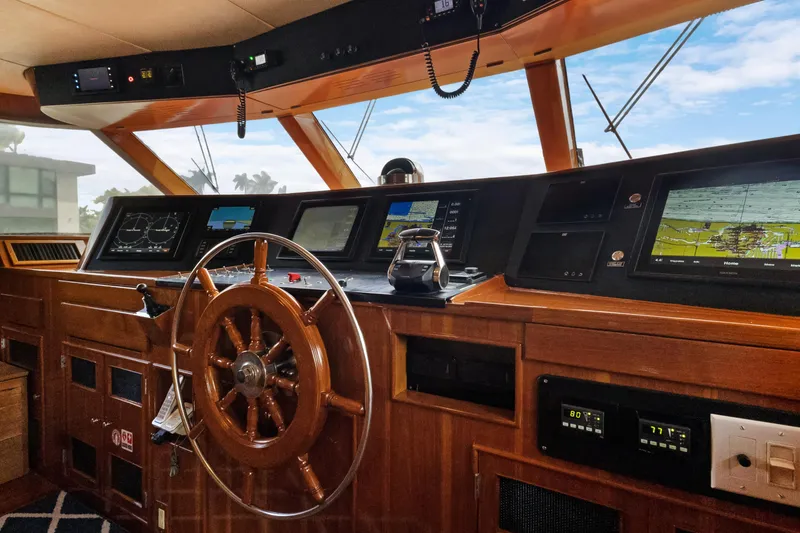 Slide: The Image of Vintage 1985 Burger yacht helm with wooden wheel and modern navigation screens. - 34